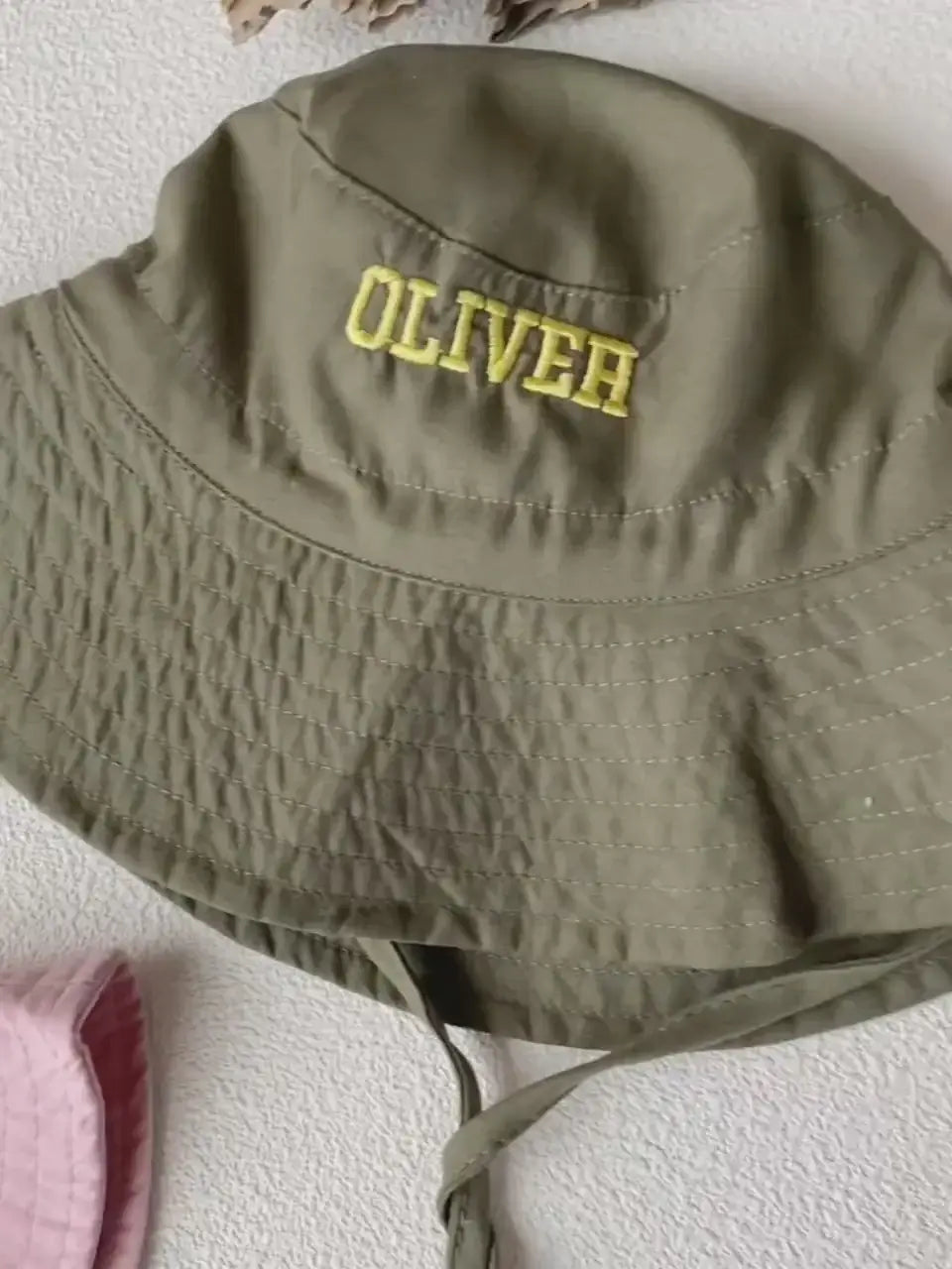 Olive green kids bucket hat embroidered with the name Oliver in yellow